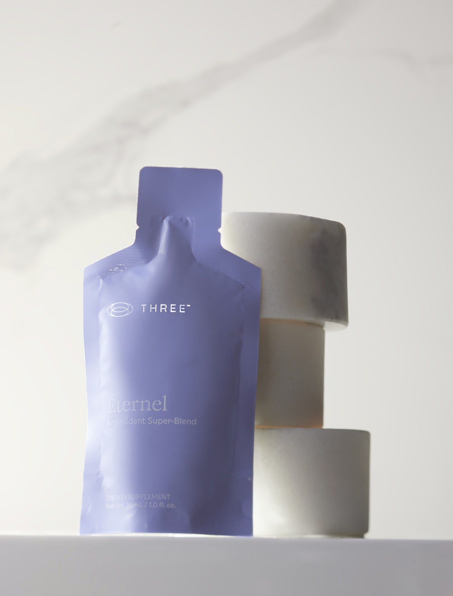 Éternel Antioxidant Super-Blend pouch displayed against a minimalist background, representing THREE’s approach to bioavailable antioxidant support.
