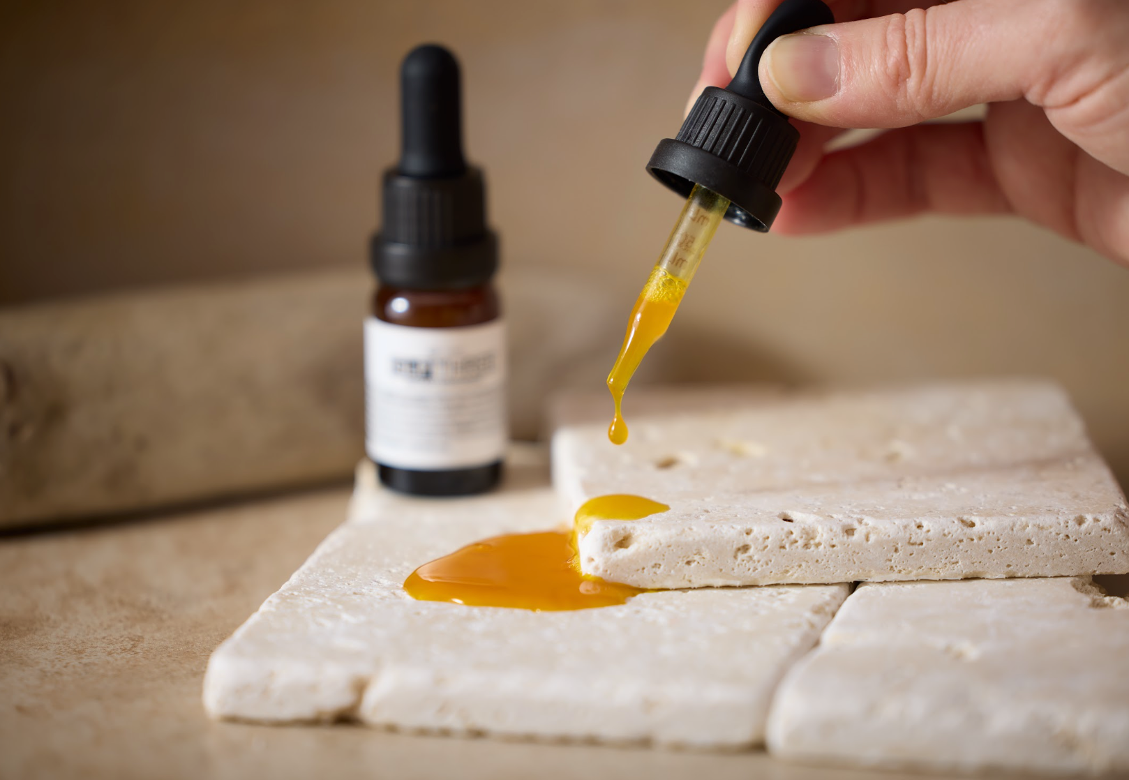A dropper dispenses the golden liquid formula from THREE GLP THREE beside a supplement bottle. GLP THREE features MBC-267 and supporting botanical ingredients in a formula designed for metabolic and natural GLP-1 support.