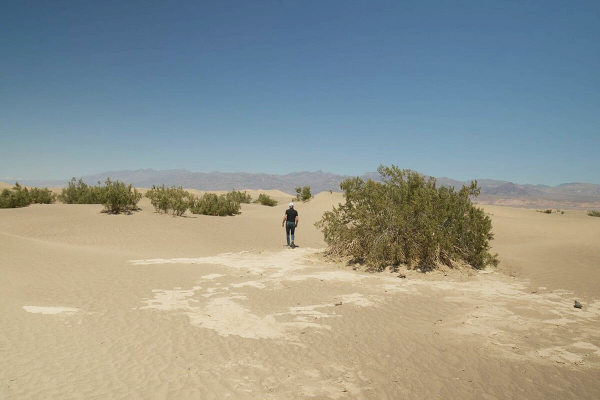 Dr Dan Gubler of THREE International walking through a barren desert in Death Valley