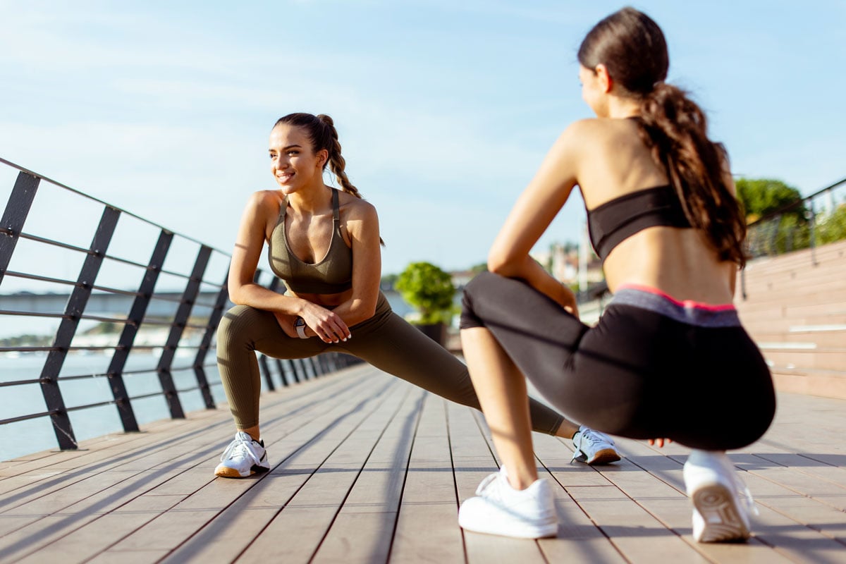 two women exercising outside embracing a healthy workout routine with a boost from Revíve by THREE supplement
